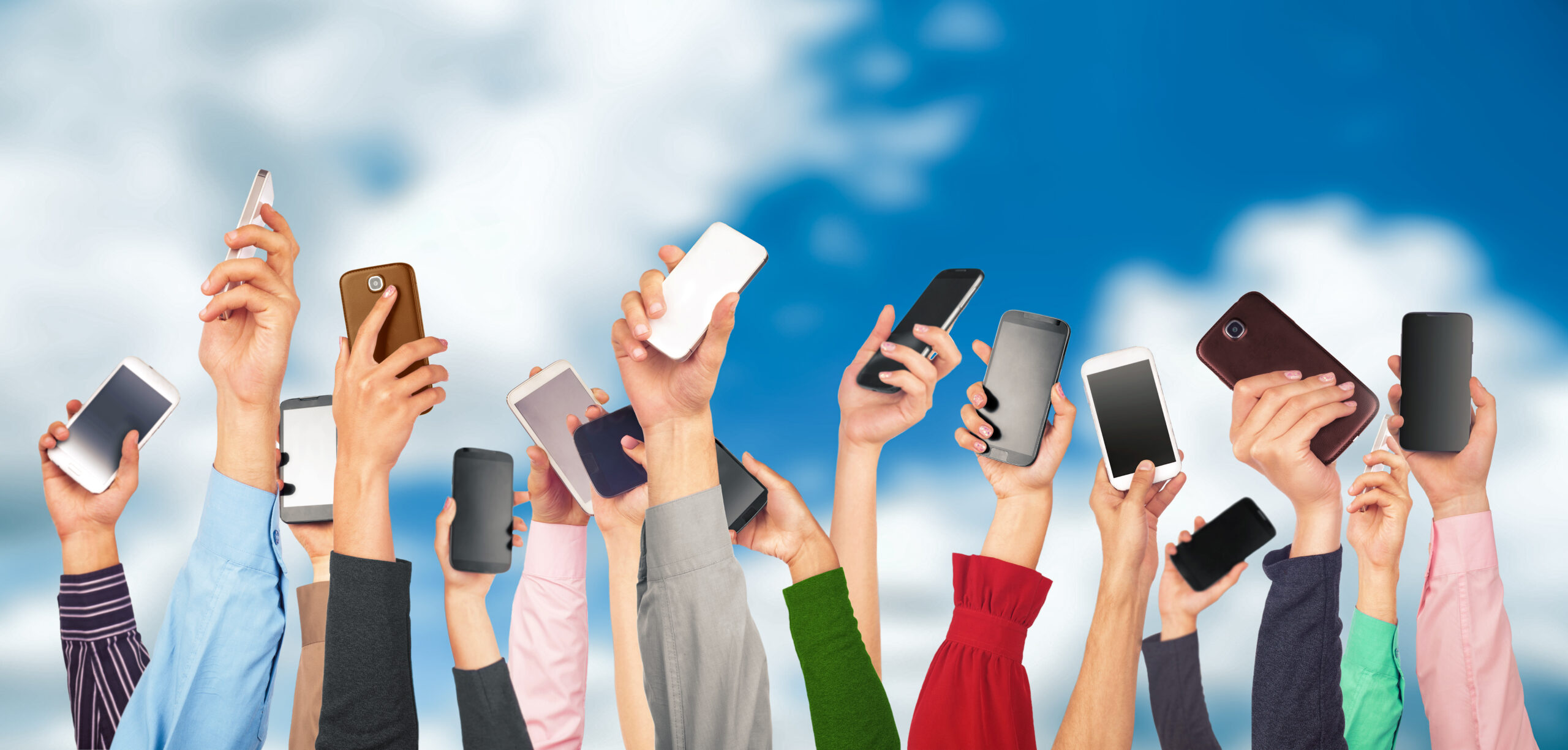 varias manos con celulares diferentes cielo azul